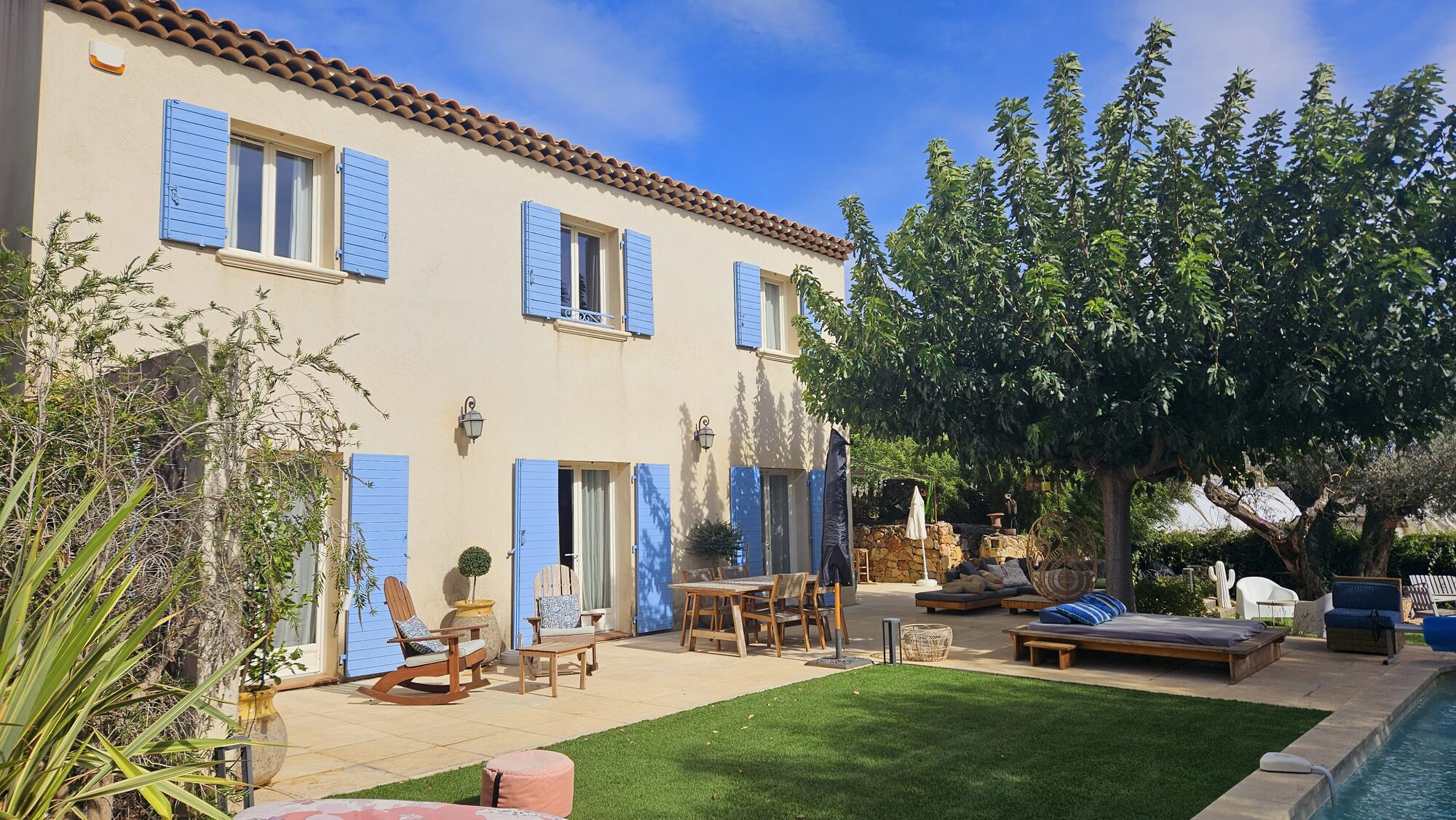 Façade de la bastide aux volets bleus, jardin et piscine